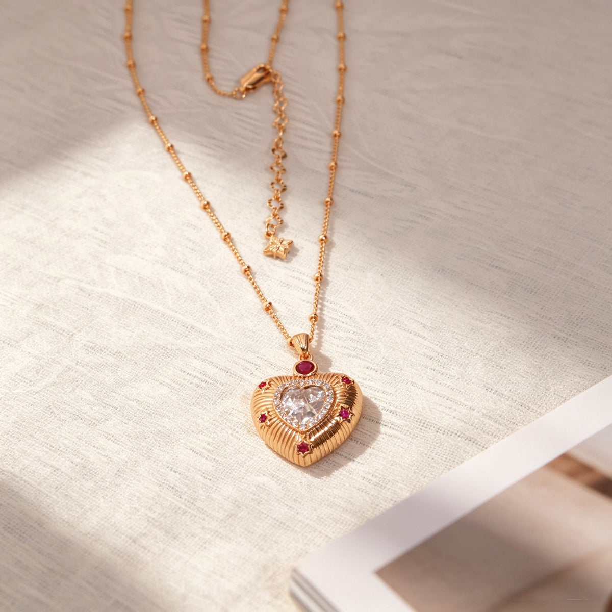 Keepsake heart necklace styled on warm neutral fabric